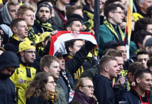 DORTMUND, GERMANY - APRIL 15: A fan in the Dortmund block holds up a 1.FC Koeln scarf during the Bundesliga match between Borussia Dortmund and Eintracht Frankfurt at Signal Iduna Park on April 15, 2017 in Dortmund, Germany. 