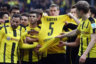 DORTMUND, GERMANY - APRIL 15: Players of Dortmund hold the jersey of their injured team mate Marc Bartra after winning the Bundesliga match between Borussia Dortmund and Eintracht Frankfurt at Signal Iduna Park on April 15, 2017 in Dortmund, Germany. 