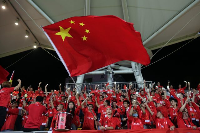 A Chinese fan waves the national flag during a world cup qualifier at Mong Kok stadium in Hong Kong on November 17, 2015. Hong Kong fans booed the anthem they share with China on Tuesday while some turned their backs and held up "boo" signs in a show of defiance before a crunch World Cup football qualifier with their mainland rivals.