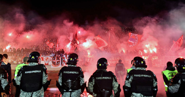Anti riot police officers stand guard as Red Star's supporters burn torches during the Serbian National soccer league derby match between Partizan and Red Star, in Belgrade on February 27, 2016. Red Star won 1-2 at the 150th edition of the 'Eternal Derby'. / AFP / ANDREJ ISAKOVIC (Photo credit should read ANDREJ ISAKOVIC/AFP/Getty Images)