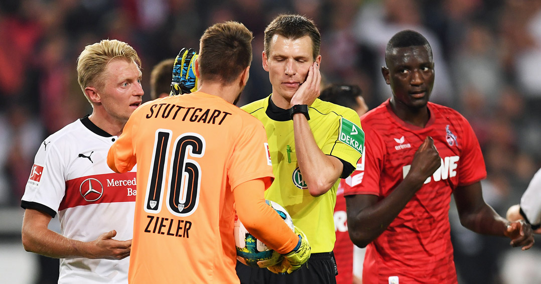 STUTTGART, GERMANY - OCTOBER 13: Referee Benjamin Cortus has a discussion with Andreas Beck of VfB Stuttgart and Ron-Robert Zieler of VfB Stuttgart before making a decision during the Bundesliga match between VfB Stuttgart and 1. FC Koeln at Mercedes-Benz Arena on October 13, 2017 in Stuttgart, Germany. (Photo by Matthias Hangst/Bongarts/Getty Images)
